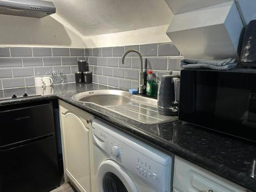 a kitchen with a sink and a washing machine at Stunning studio Apartment in Newport in Newport