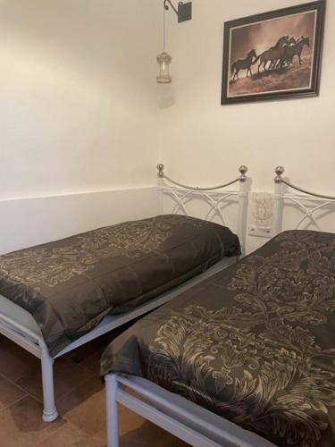 a bedroom with two beds and a picture of horses on the wall at CASA ALEGRIA in Algodonales