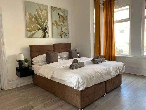 a bedroom with a large bed with two slippers on it at Captivating 1-Bed Apartment in Newport in Newport