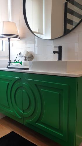 a green cabinet with a sink and a lamp on it at Casa "Vô Lando" - Nazaré - Alojamento Local in Nazaré