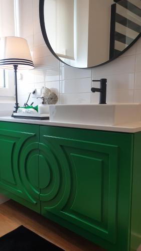 um armário verde com um lavatório e um candeeiro em Casa "Vô Lando" - Nazaré - Alojamento Local na Nazaré