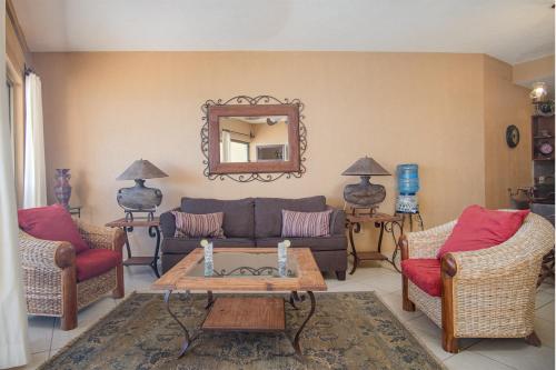 een woonkamer met een bank, stoelen en een spiegel bij Sonoran Sun 2BR SE 703 by Casago in Puerto Peñasco