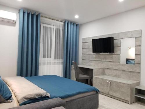 Schlafzimmer mit einem Bett, einem Schreibtisch und einem TV in der Unterkunft Lux na Druhetiv in Uschhorod