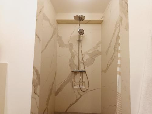 a shower in a bathroom with a wall at Happy Stay Paris - Suite Hotel de Ville le Marais in Paris
