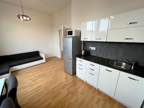 a kitchen with white cabinets and a stainless steel refrigerator at Holiday home Prague in Prague