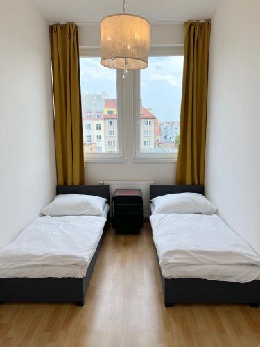two beds in a room with a window at Holiday home Prague in Prague