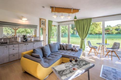 a living room with a yellow couch and a kitchen at Vilka u Dyje in Znojmo