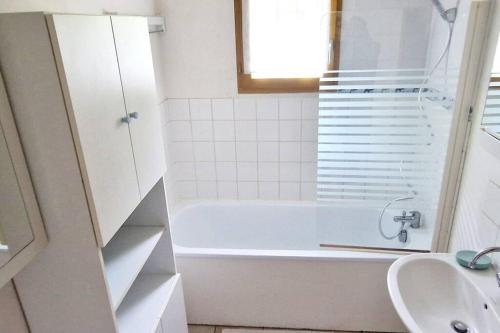 a white bathroom with a tub and a sink at Belle maison spacieuse proximité mer in Le Crotoy
