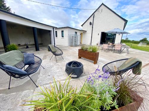 a patio with chairs and plants and a building at Dillon School House - Luxury in the countryside in Roscommon