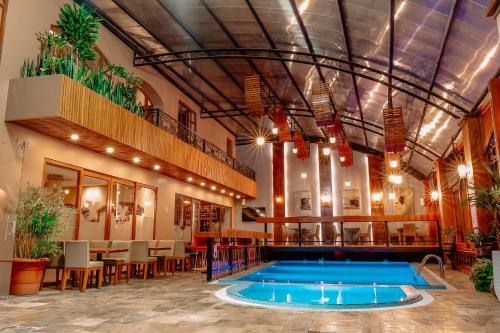 una piscina en el medio de un edificio con un restaurante en Grand Victoria Boutique Hotel, en Loja
