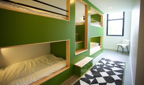 a bedroom with a green wall with bunk beds at Dillon School House - Luxury in the countryside in Roscommon