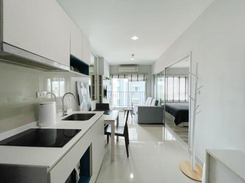 a kitchen with a sink and a living room at 芭提雅Fnb Central 无边泳池 in Pattaya