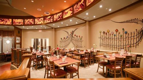 ein Restaurant mit Tischen und Stühlen und einem Gemälde an der Wand in der Unterkunft Best Western Plus Lamplighter Inn & Conference Centre in London