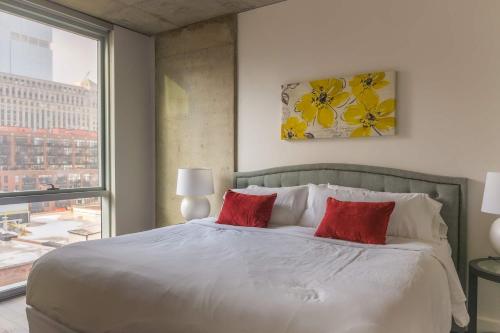 a bedroom with a large white bed with red pillows at 2BR Executive Suite With Fast Wi-Fi in Chicago
