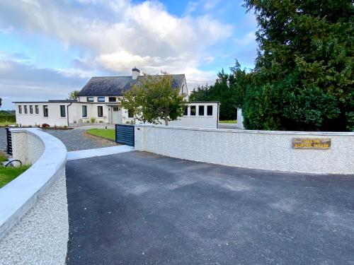 a driveway in front of a white house at Dillon School House - Luxury in the countryside in Roscommon