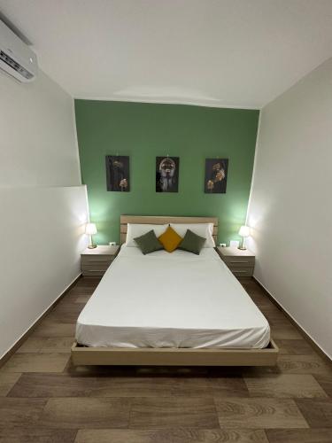 a bedroom with a large white bed with green walls at CP House in Naples