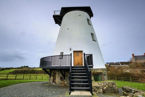 a lighthouse with a staircase leading up to it at Melin Y Bont in Bodorgan
