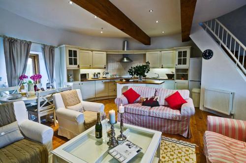 a living room with two couches and a kitchen at Melin Y Bont in Bodorgan