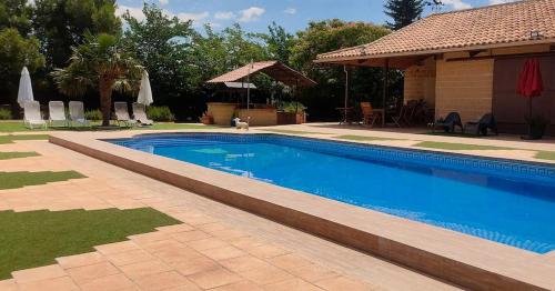 a swimming pool in a yard next to a house at Finca El Pilar in Madridejos