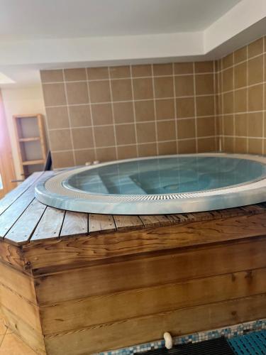 une baignoire jacuzzi sur une plate-forme en bois dans une chambre dans l'établissement Arc 1950 Ap 171 Résidence les Sources de Marie, à Bourg-Saint-Maurice