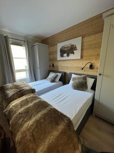 two beds in a room with wooden walls at Arc 1950 Ap 171 Résidence les Sources de Marie in Bourg-Saint-Maurice