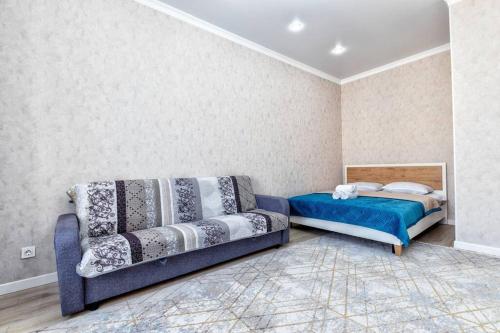 sala de estar con sofá y cama en Alma Park 1, en Taldykolʼ