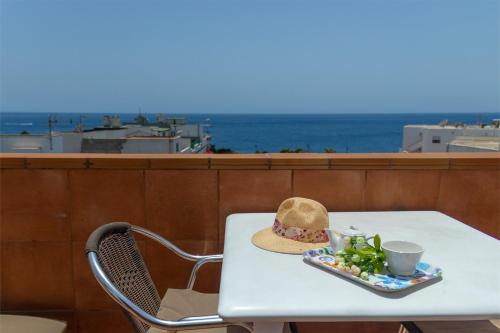 a table with a hat and a plate of food at Hostal Magec in Puerto del Carmen