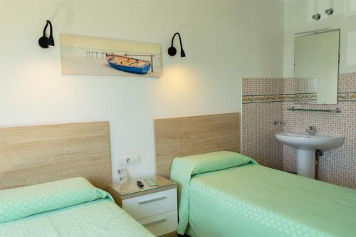 łazienka z 2 łóżkami, umywalką i umywalką w obiekcie Hostal Magec w Puerto del Carmen