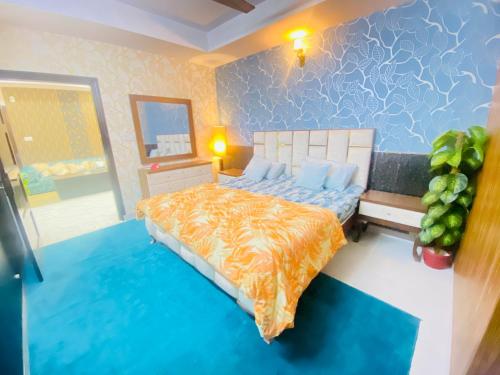 Viceroy Luxury Hotel Apartments Islamabad في اسلام اباد: غرفة نوم مع سرير مع لحاف برتقالي وزرق