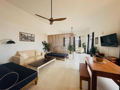 a living room with a couch and a ceiling fan at Amara Living in Cartagena de Indias