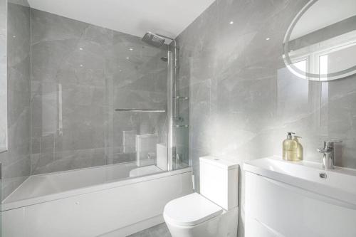 a bathroom with a toilet and a shower and a sink at Cosy Tooting Retreat: 2-Bed Gem in London