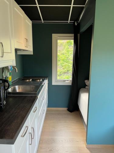 a small kitchen with a sink and a window at Overnatting med sjøutsikt å rolige omgivelser in Alta
