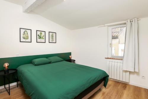 um quarto com uma cama verde e uma janela em Le T2 Chic ! em Carcassonne