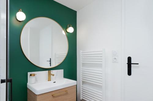 uma casa de banho com um lavatório branco e um espelho. em Le T2 Chic ! em Carcassonne