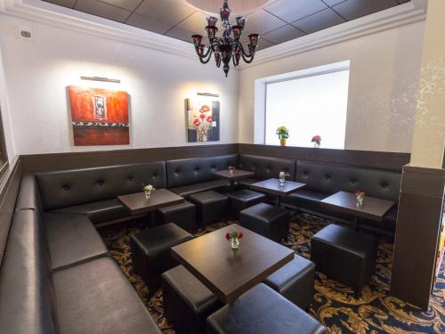 a restaurant with tables and chairs and a chandelier at Hôtel Irlande in Lourdes