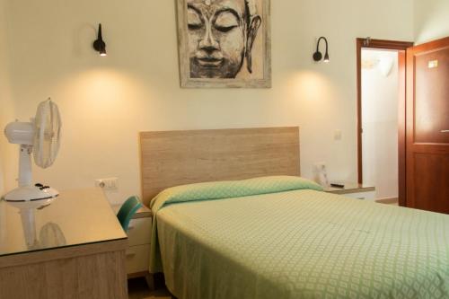 a bedroom with a bed and a painting on the wall at Hostal Magec in Puerto del Carmen