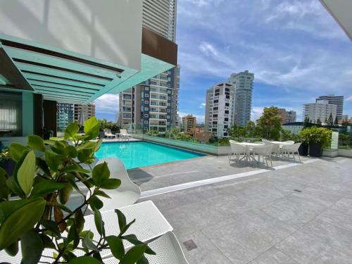 a swimming pool on a building with tables and chairs at Elegant City Center Condo in Santo Domingo