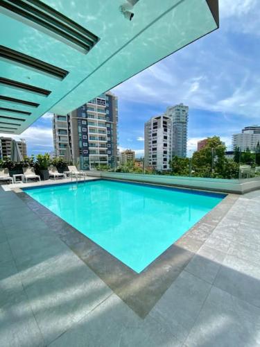 a large swimming pool with a view of some buildings at Elegant City Center Condo in Santo Domingo