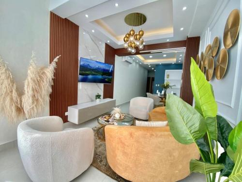 a living room with white chairs and a couch at Elegant City Center Condo in Santo Domingo