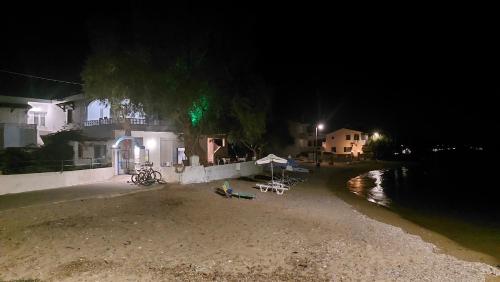 a beach at night with a house and a building at Fotis beach apartment at Komi in Kómi