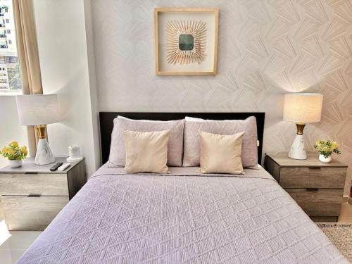 a bedroom with a bed with two nightstands and two lamps at Beautiful Condo in Bella Vista in Los Prados