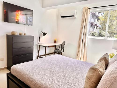 a bedroom with a bed and a desk and a window at Beautiful Condo in Bella Vista in Los Prados