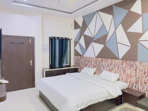 a bedroom with a bed and a geometric wall at ALOK RESIDENCY in Satna
