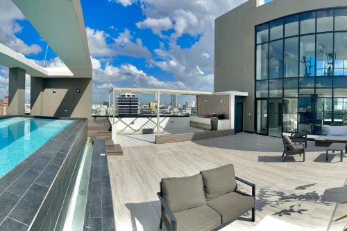 une grande maison avec une piscine sur le toit dans l'établissement Stunning City Center Condo, à Los Prados