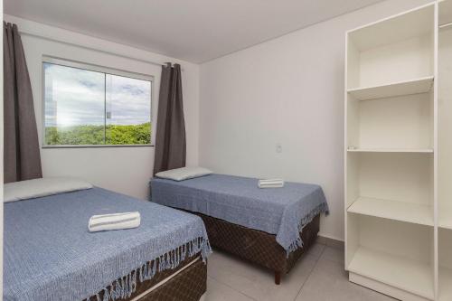 2 camas en una habitación con ventana en Sobrado frente ao mar Mariscal 4 Pessoas, en Bombinhas