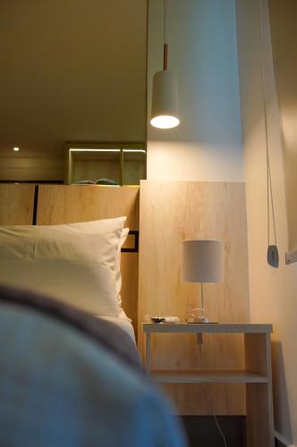 a bedroom with a bed and a table with a lamp at Hotel Black Inn Flamboyant in Goiânia