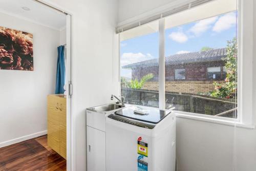 a kitchen with a sink and a window at The Brickstone Home with Deck and Parking in Auckland