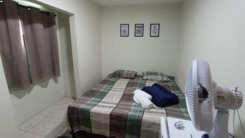 a bedroom with a bed and a fan at Rioli quarto 2 in Caruaru