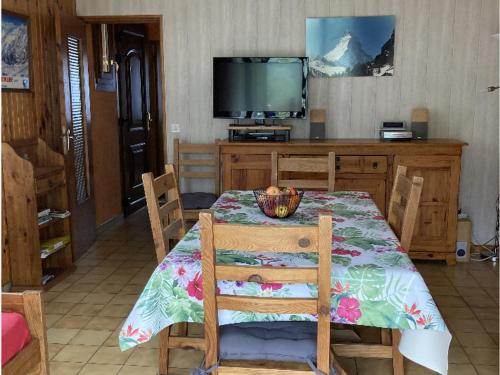 une salle à manger avec une table et une télévision dans l'établissement Charmant 2 pièces avec parking et Wi-Fi à Saint-Chaffrey - FR-1-762-46, à Saint-Chaffrey
