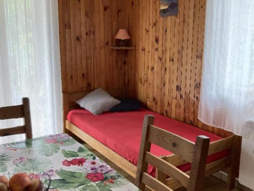 une petite chambre avec un lit et une table dans l'établissement Charmant 2 pièces avec parking et Wi-Fi à Saint-Chaffrey - FR-1-762-46, à Saint-Chaffrey